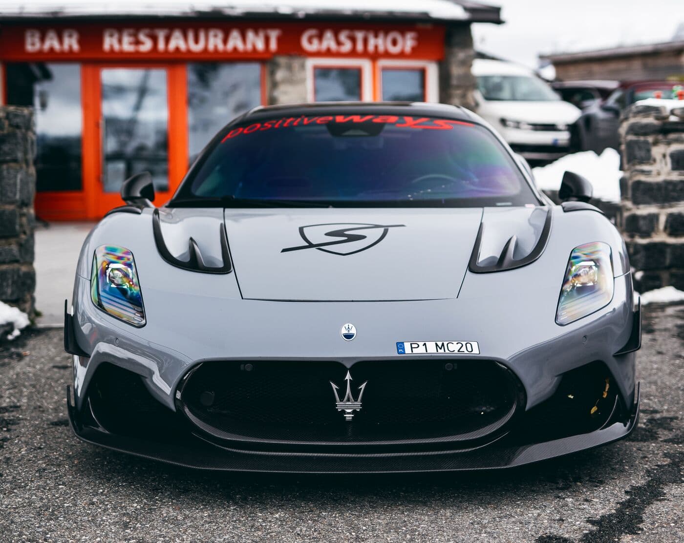 Srebrne Maserati MC20 przed alpejskim schroniskiem