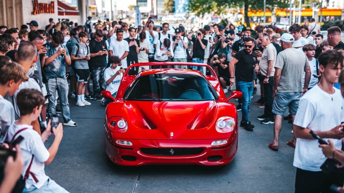 Tłum ludzi wokół czerwonego Ferrari F50 na postoju